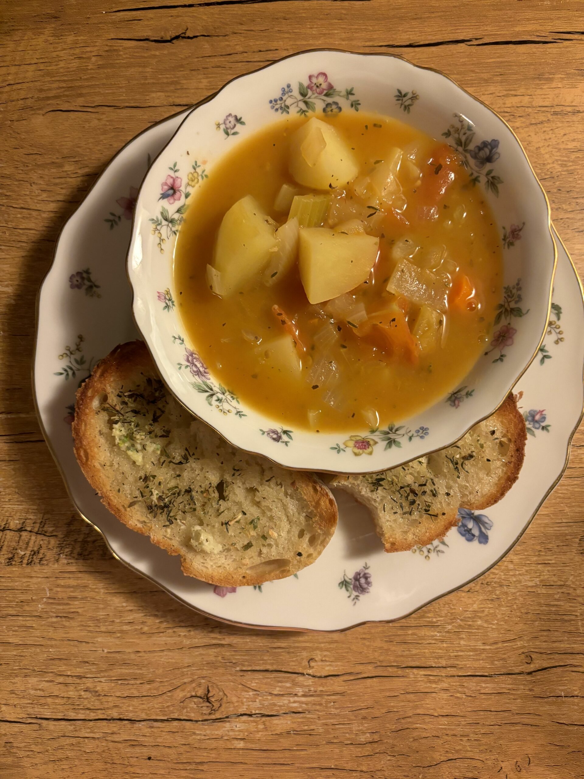 Bowl of Soup and Two Pieces of Bread on a Plate